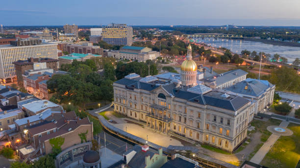 The capital statehouse of New Jersey lights up as the sun sets the Delaware River in the background city of Trenton. Call our Commercial Locksmith NJ now